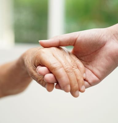 Close-up of an elderly person's and caregiver's hands