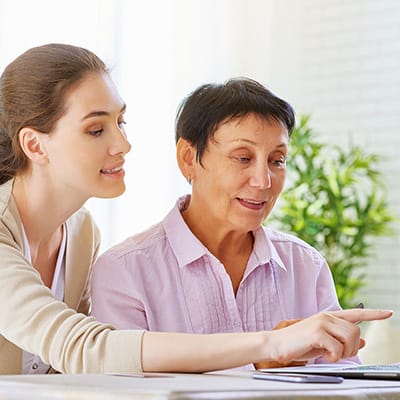 A staff member assisting a resident in a bright interior