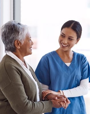 A caregiver and resident smiling at each other