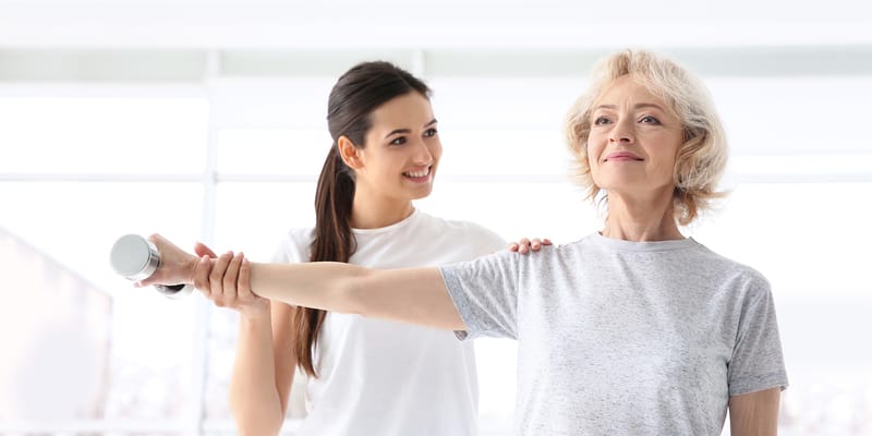 Therapist assisting a resident with exercises