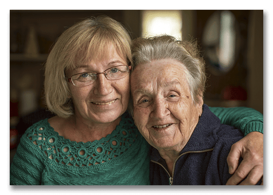 Two residents smiling and embracing in a cozy setting