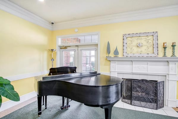 Interior of a common area with a piano and fireplace