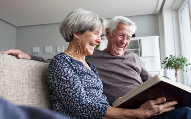 Couple sharing a joyful moment looking at a photo book