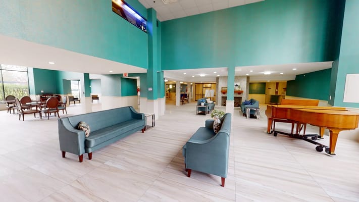 Bright common area with seating and a piano