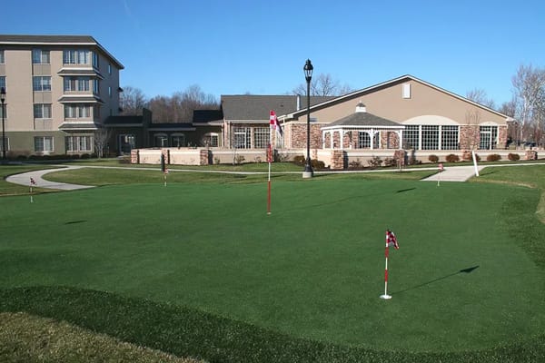 Outdoor space with putting greens and building in background