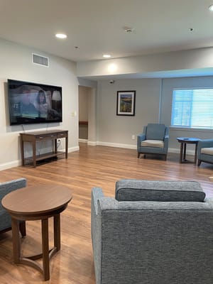 Common area with seating and television in a senior living facility