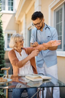 Healthcare professional measuring a resident's blood pressure outdoors