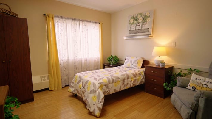 A private resident room with a bed and decor