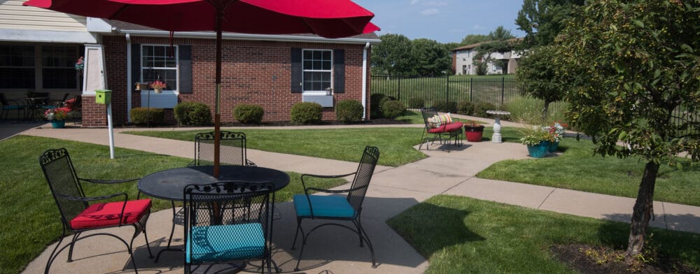 Outdoor seating area with red umbrellas and garden views