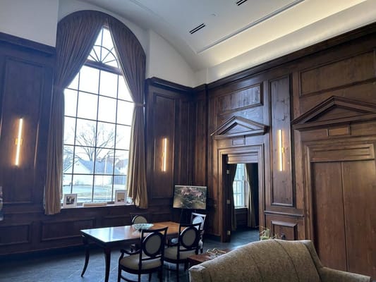 Common area with wooden paneling and large windows