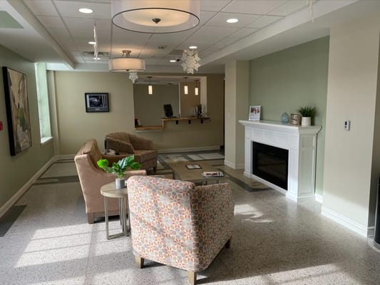Bright lobby area with seating and a fireplace