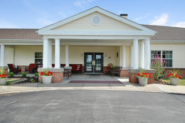 Exterior view of a senior living facility entrance with seating