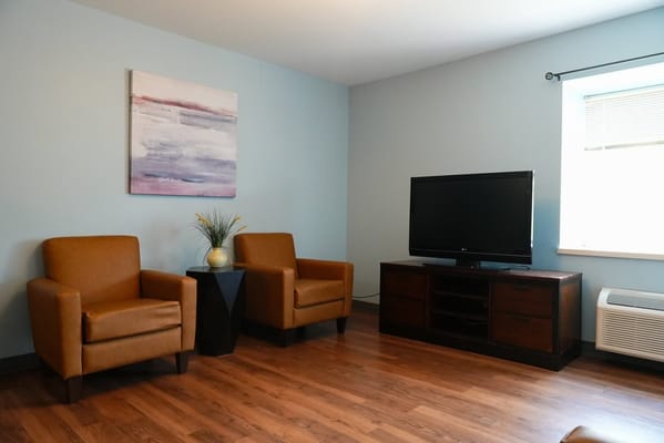 Cozy seating area with two chairs and a TV