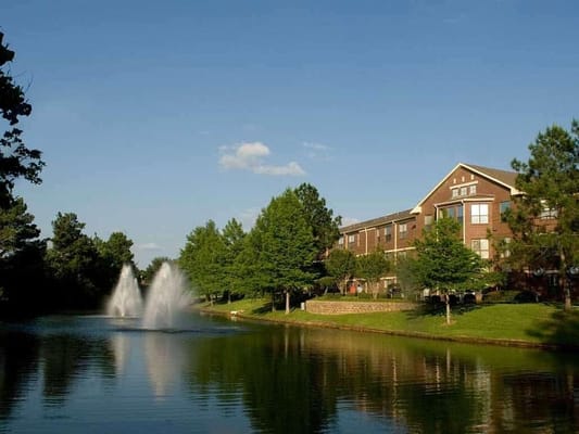 Exterior view of a nursing home by a pond with fountains