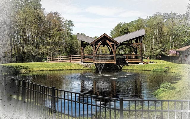 Wooden pavilion overlooking a pond with a fountain