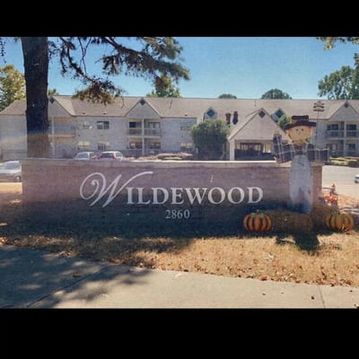 Sign for Wildewood Independent Living with pumpkins and a scarecrow