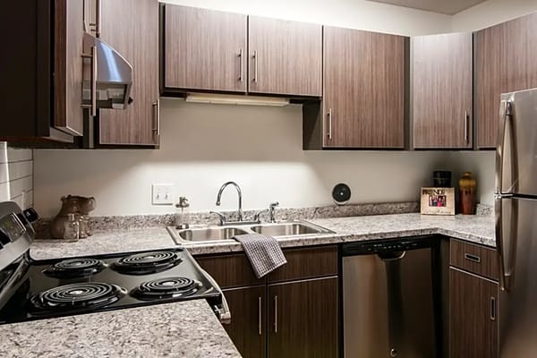 A modern kitchen with stainless steel appliances and wooden cabinets.