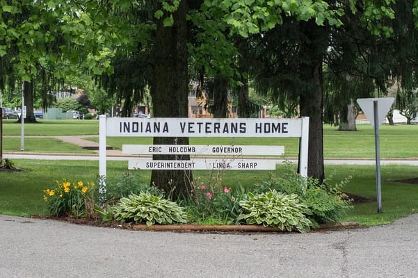 Signage for Indiana Veterans Home with flowers in front