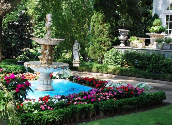 A decorative garden fountain surrounded by colorful flowers.