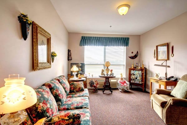 A cozy resident room with floral decor and furniture