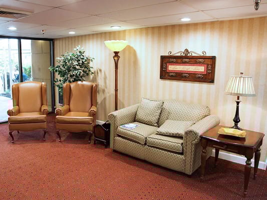 Cozy seating area with armchairs and a sofa in Regency Healthcare's lounge.