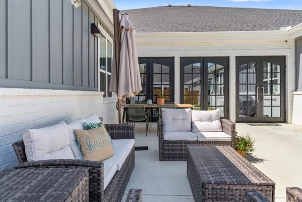 Outdoor seating area with couches and umbrella