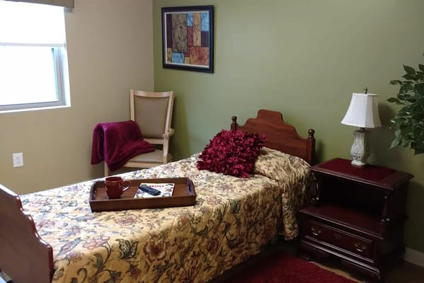 Cozy interior of a resident's bedroom with a bed and lamp
