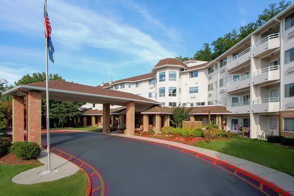 Entrance view of Holiday Elm Park Estates with landscaping and flagpole.