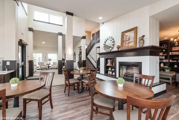 Cozy living room with tables, chairs, and a fireplace