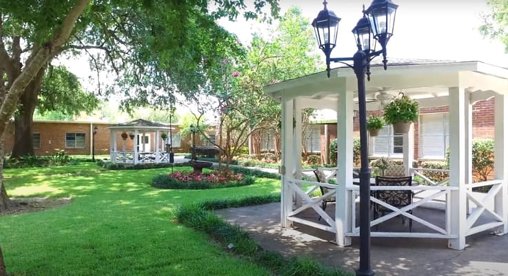 A peaceful garden area with a gazebo and flowers
