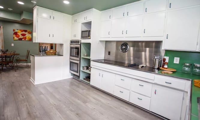 Modern kitchen interior with white cabinets and stainless steel appliances