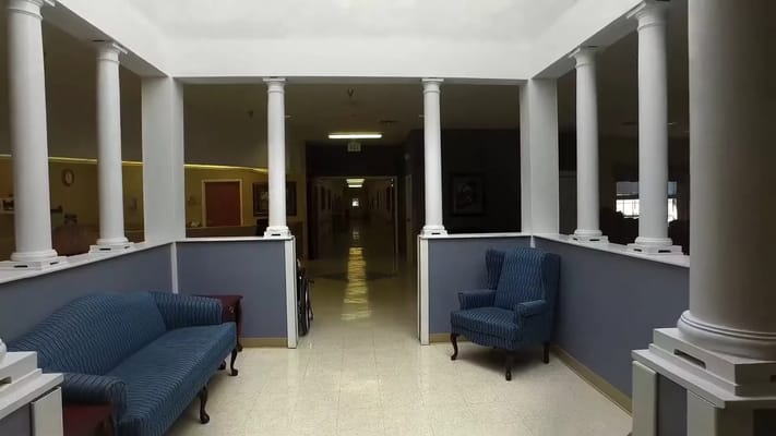 Interior view of a common area with blue chairs and columns