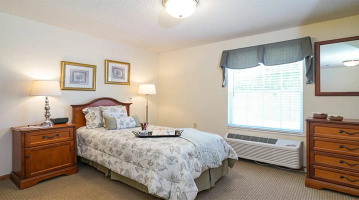 Bedroom featuring a bed, nightstands, and window