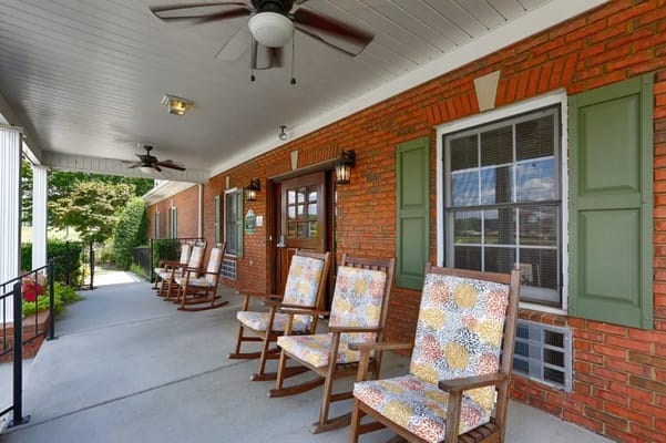 Rocking chairs on a covered porch at a senior living facility