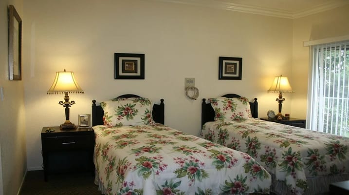 Cozy twin bedroom with floral bedding and lamps