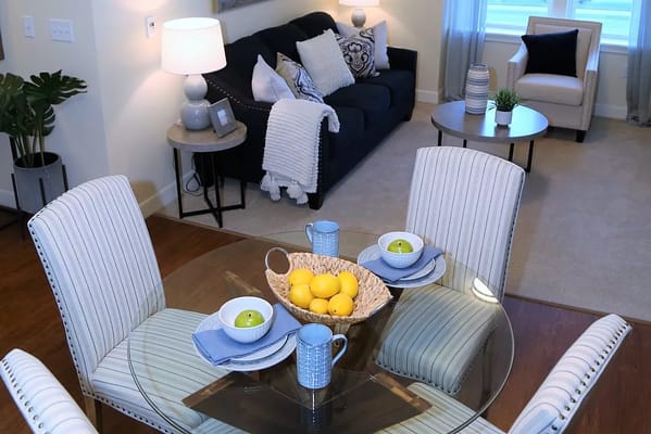 Cozy living room and dining area with a glass table and fruit bowl