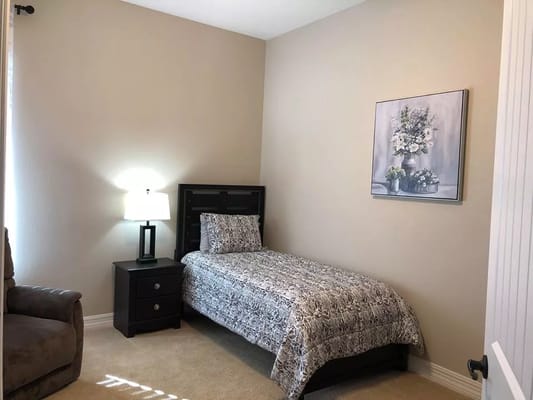 Cozy private resident room with a single bed and lamp