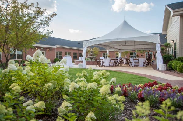 Outdoor gathering space with a tent and colorful flowers