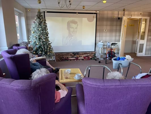 Residents watching a movie in a cozy lounge area