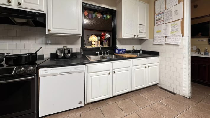 Clean kitchen area with white cabinets and countertop