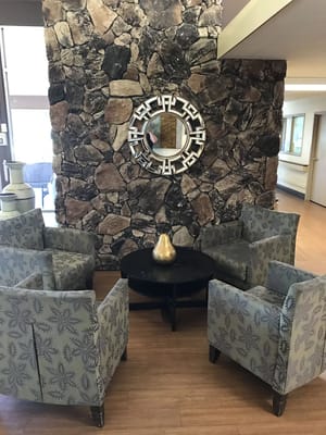 Common area with seating and decorative stone wall
