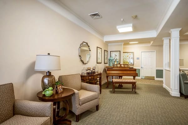 Cozy lobby with seating, lamp, and piano