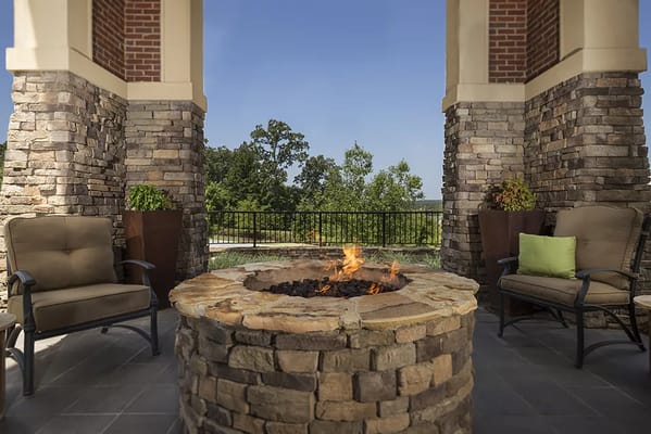Outdoor seating area with fire pit and stone columns