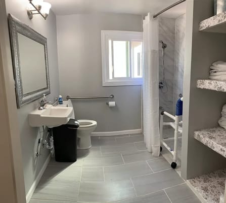 Spacious bathroom with grab bars and shower area