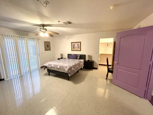Spacious bedroom with a bed, nightstand, and sliding doors