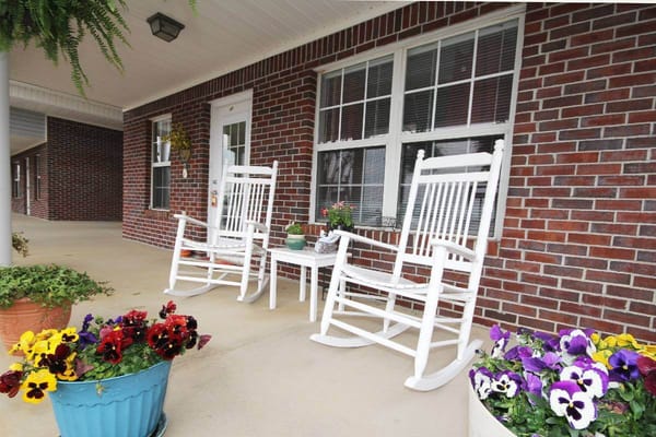Outdoor seating area with rocking chairs and flowers