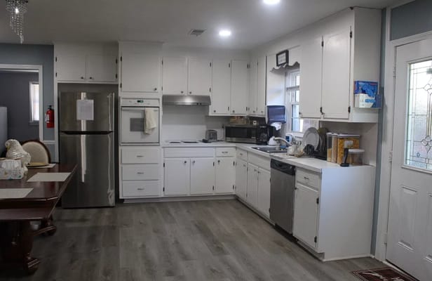 Well-lit kitchen area with appliances and dining table