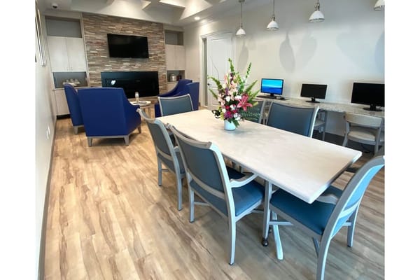 Bright common area with a dining table and computers