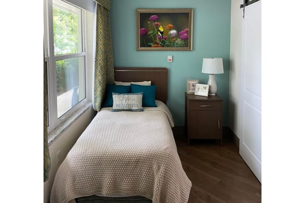 Cozy private resident room with a single bed and artwork