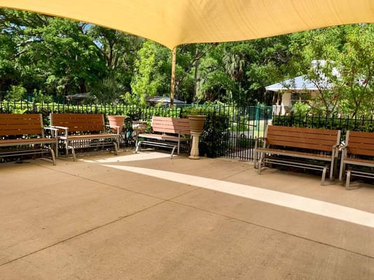 Outdoor seating area with benches under a canopy